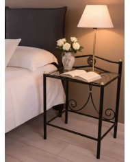 Comodino Laura in ferro battuto artigianale, finitura Nero oro, con doppio ripiano in vetro. Stile elegante e sobrio.