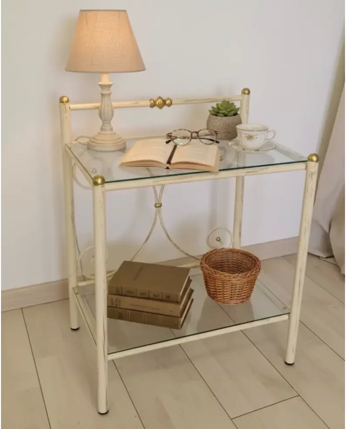 Comodino Mimosa in ferro battuto artigianale, finitura Avorio decorato oro, con doppio ripiano in vetro. Prodotto Made in Italy.
