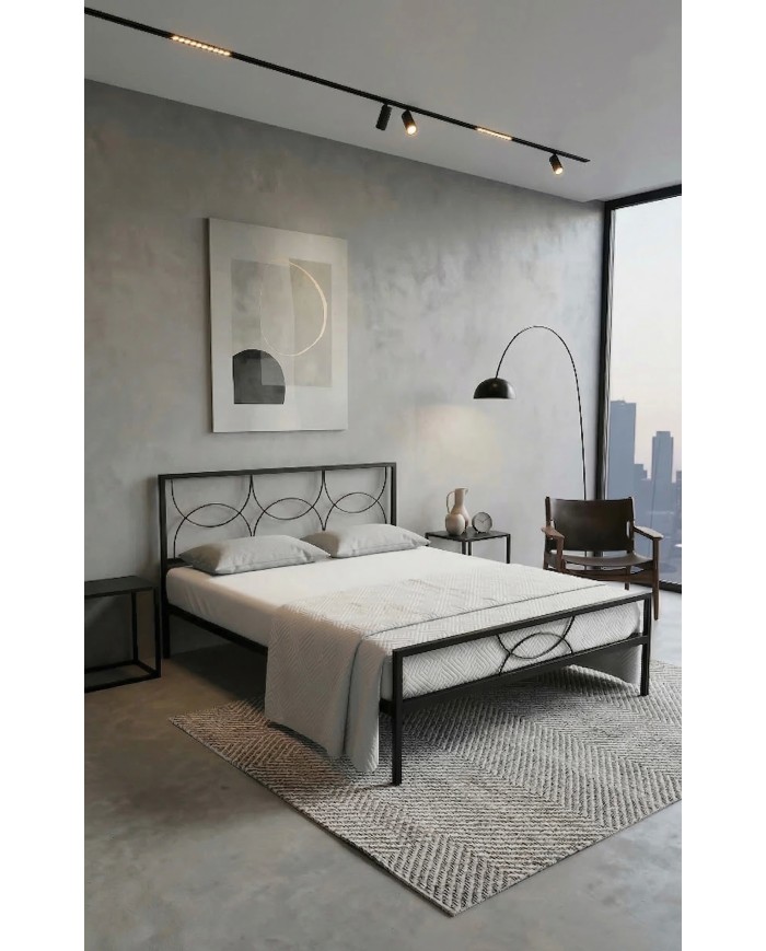 Letto in ferro nero Aura con testata a cerchi moderni e rete a doghe integrata. Design minimale e struttura robusta artigianale.