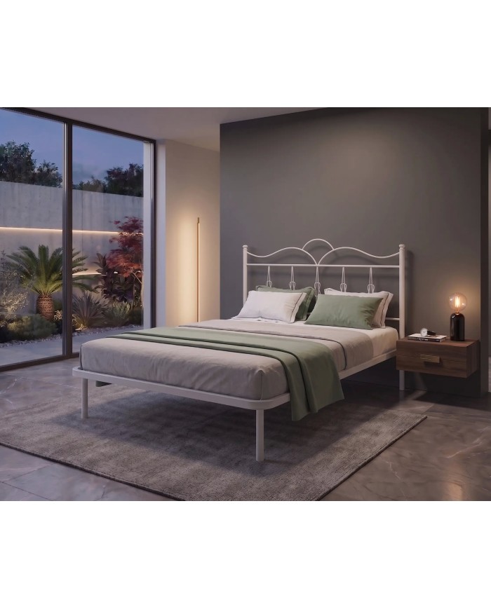 Letto in ferro Fiocco con testata ondulata e decori a nodo. Struttura con rete a doghe integrata, design romantico e artigianale