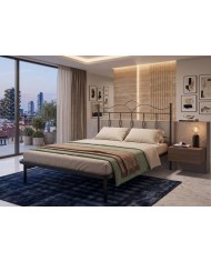 Letto in ferro Fiocco con testata ondulata e decori a nodo. Struttura con rete a doghe integrata, design romantico e artigianale