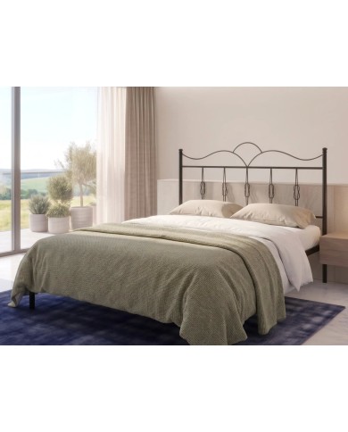 Letto in ferro Fiocco con testata ondulata e decori a nodo. Struttura con rete a doghe integrata, design romantico e artigianale